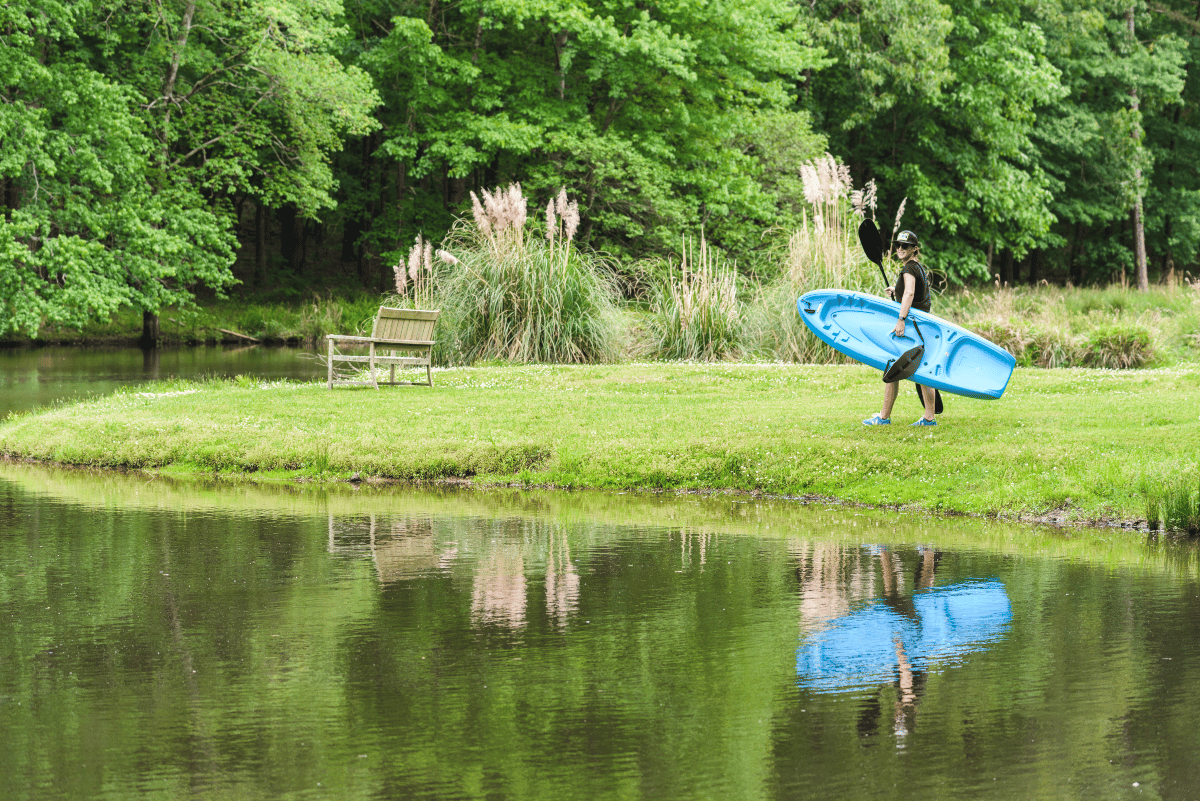 A Shoal Creek resident holds a kayak by the lake, one of many fall sports and activities to enjoy in Birmingham.