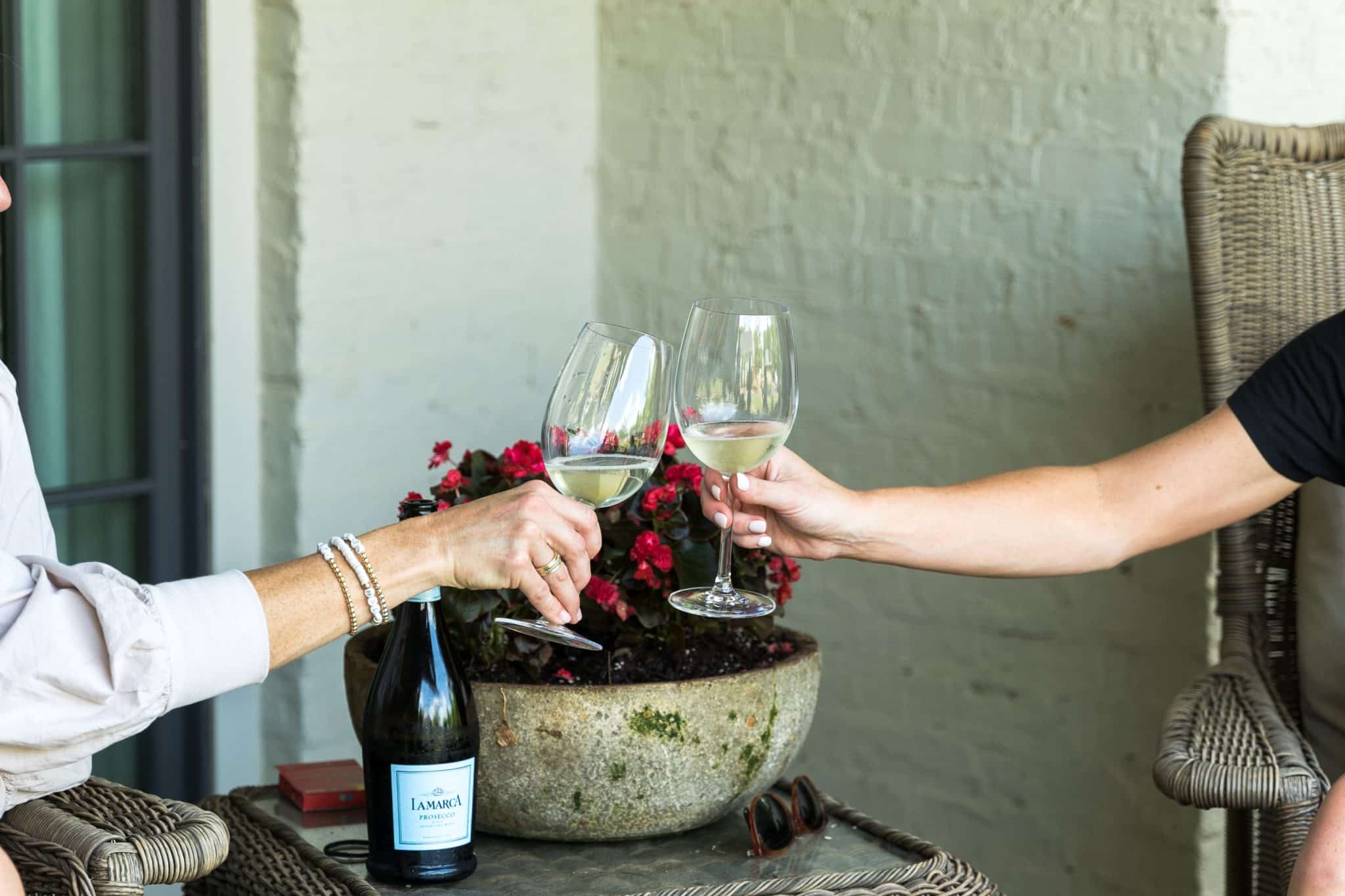 Two Shoal Creek residents toast the holiday season with glasses of Prosecco