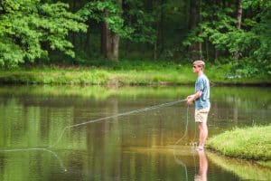 A young male resident goes fishing in one of Shoal Creek's lakes