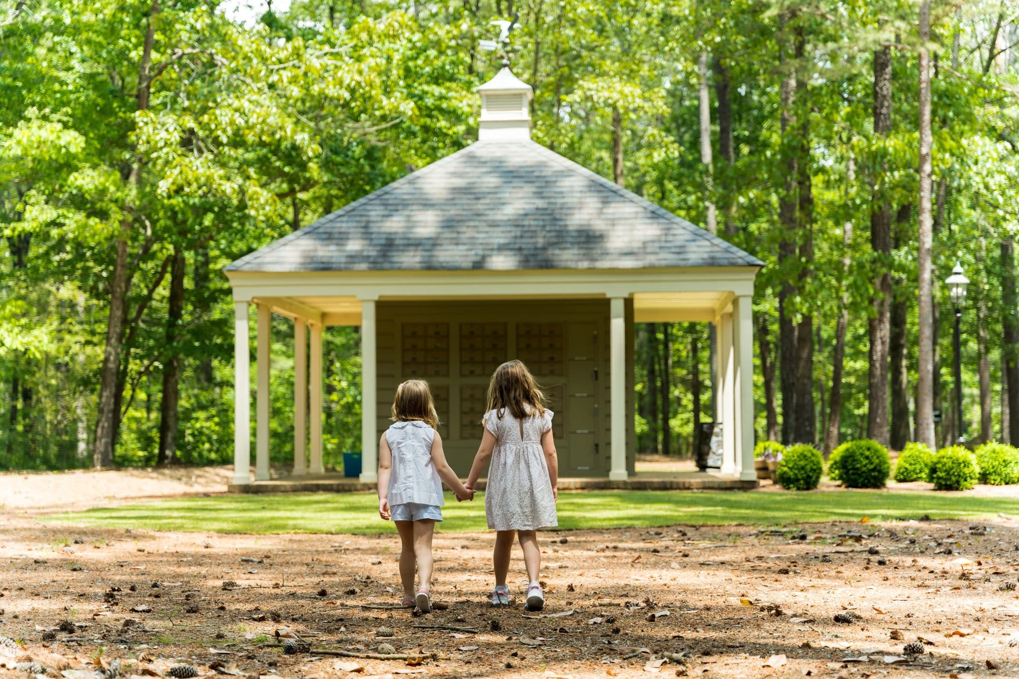 Two little girls walk hand in hand toward a community building in the Shoal Creek luxury neighborhood