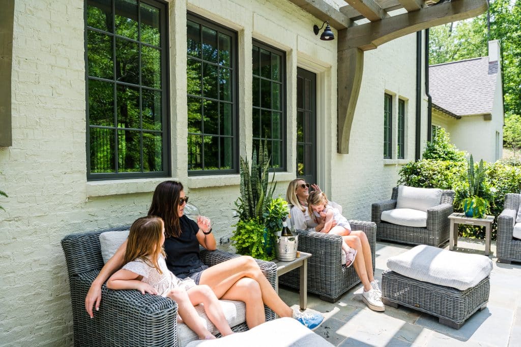 Two Shoal Creek residents and their daughters enjoy a glass of wine on the patio