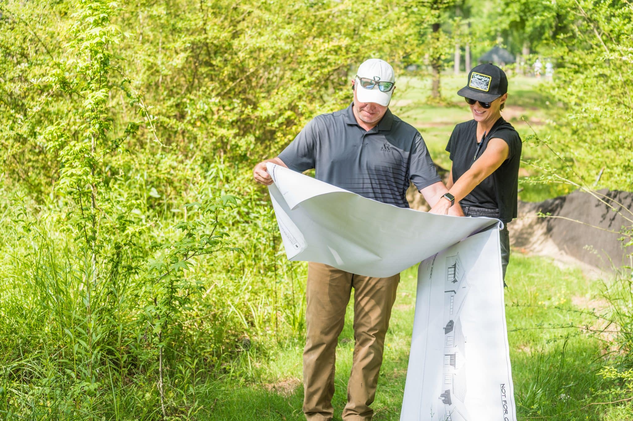 A home builder looks over architectural plans to discuss new home layout ideas