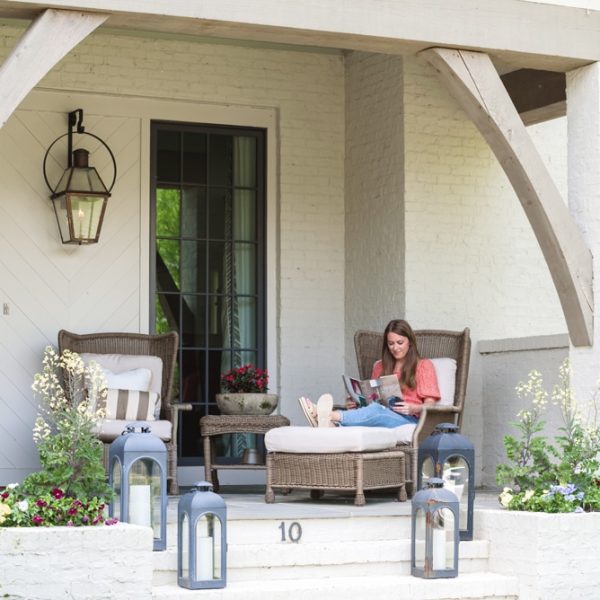 Woman reading a book in front of a house