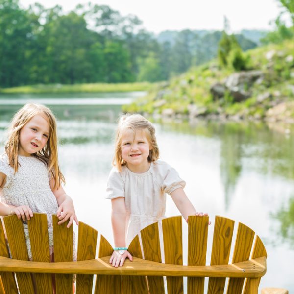 Two girls looking at the photo in front of a beautiful lake